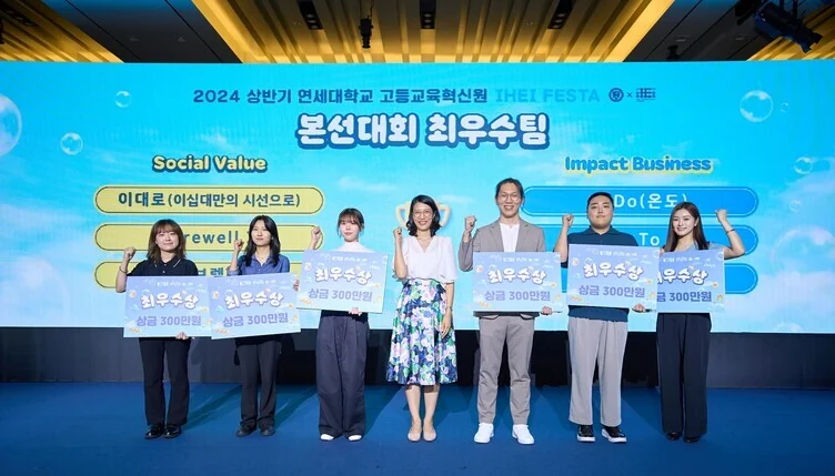 Award winners on stage at the 2024 IHEI Festa, holding prize boards
